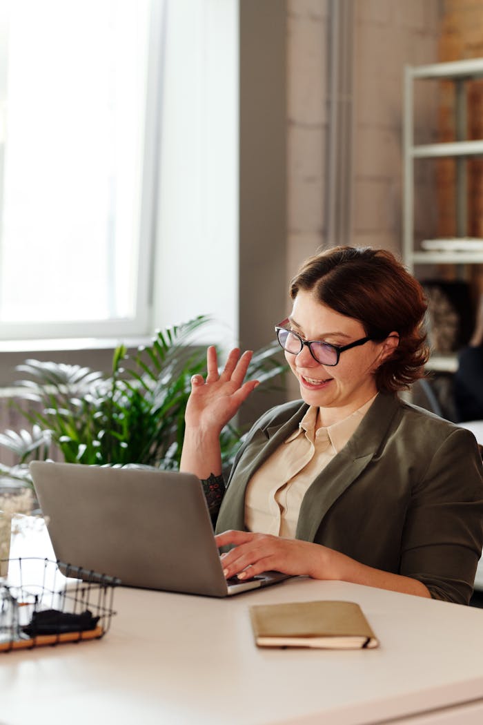 Businesswoman in glasses on a video call in a stylish office setting.